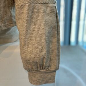 Textured grey crop top with high end details to sleeves and high V backside.